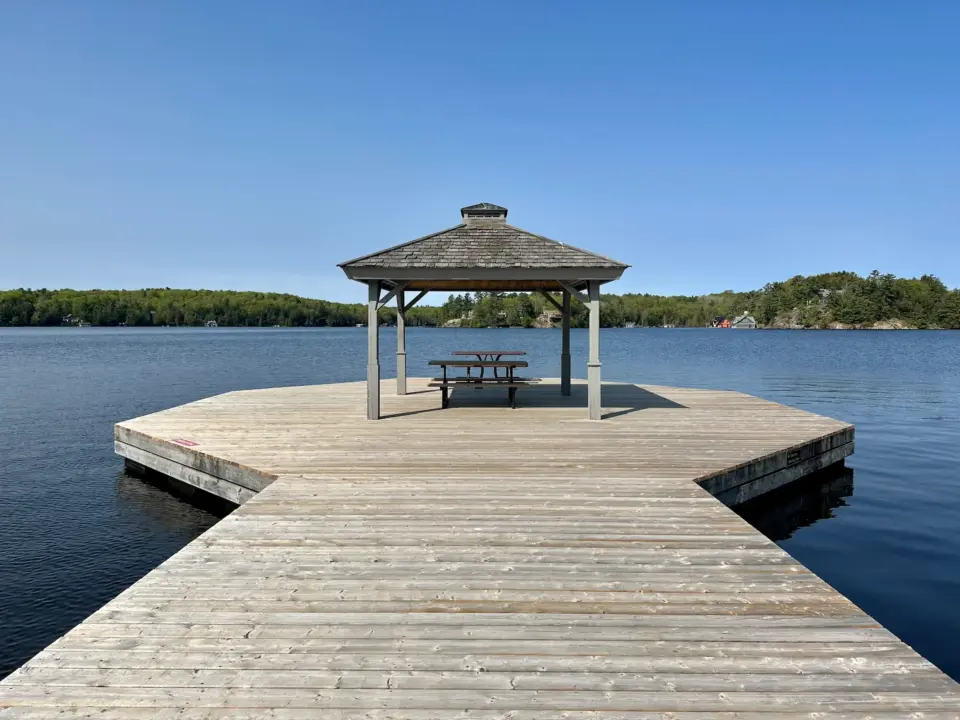 A dock on Lake Rosseau with a Cabana and picnic tables.