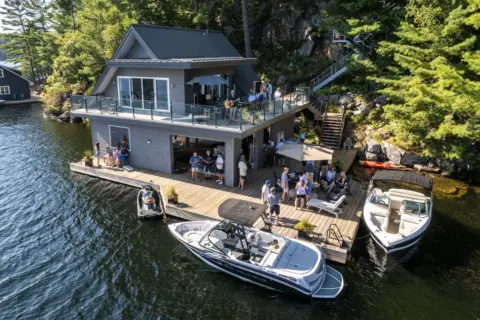 A drone shot of a LRNA social event happening at a boat house on Lake Rosseau.